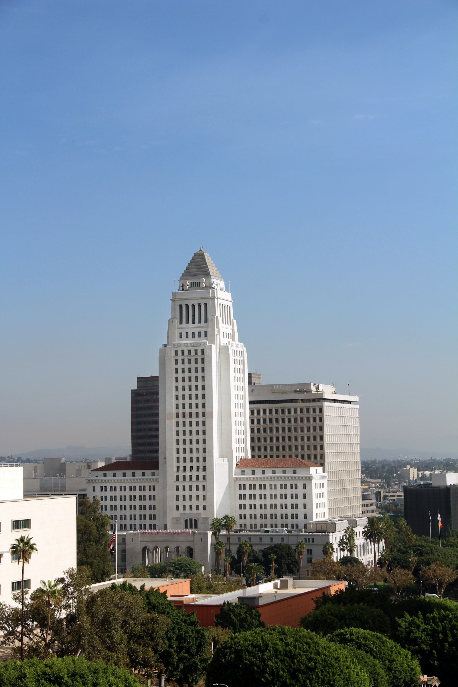 A city hall tower rising above downtown on a clear day